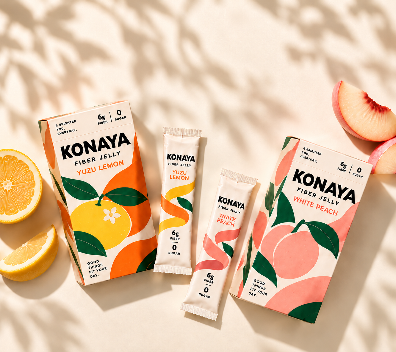 KONAYA Yuzu Lemon and White Peach boxes and jelly sticks in an overhead flat lay with sliced citrus and peach.